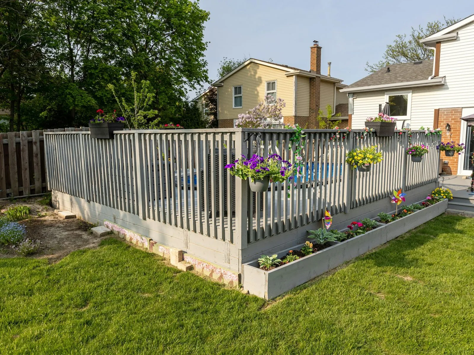 Backyard deck with built-in planter boxes and a new lawn